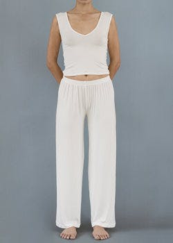 Model wearing Kye Recline Pant bamboo long pants in white. The loose fit and soft bamboo fabric offer a comfortable and stylish option for lounging or casual wear by Kye Intimates.